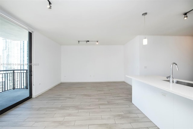 unfurnished room featuring sink, expansive windows, and rail lighting