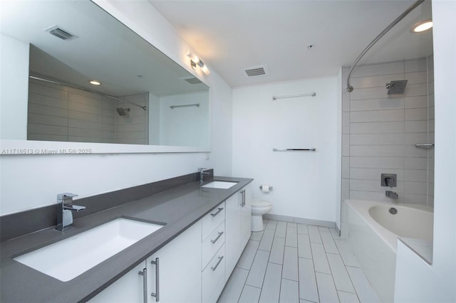 full bathroom with tiled shower / bath combo, toilet, and vanity