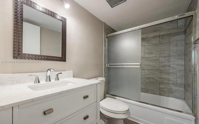 full bathroom with shower / bath combination with glass door, vanity, and toilet