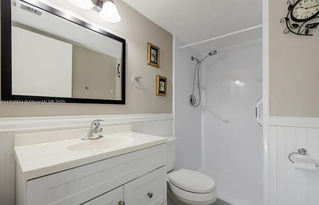 bathroom featuring a shower, vanity, and toilet