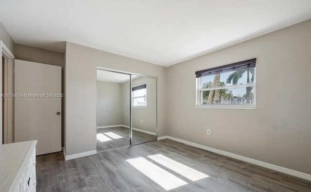 unfurnished bedroom with hardwood / wood-style flooring and a closet