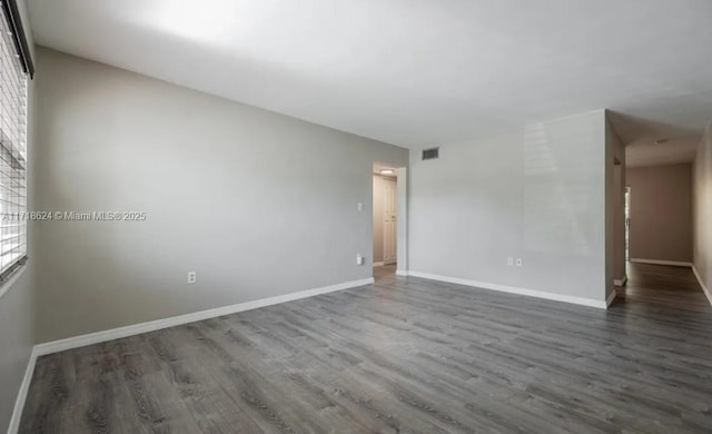 unfurnished room with a wealth of natural light and dark hardwood / wood-style flooring