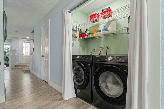 laundry area with separate washer and dryer and light wood-type flooring