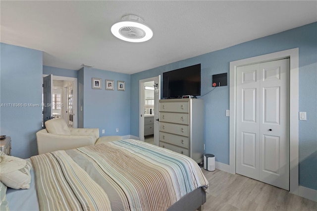 bedroom with light wood-type flooring and connected bathroom