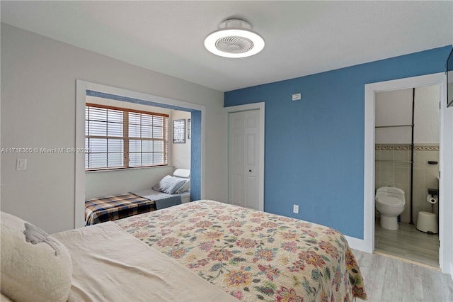 bedroom featuring hardwood / wood-style flooring and ensuite bath