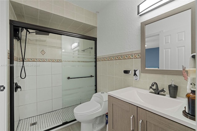 bathroom with walk in shower, vanity, toilet, and tile walls