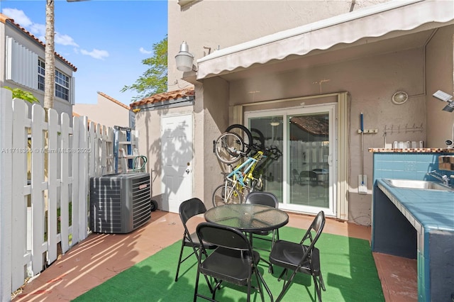 view of patio with central AC unit and sink