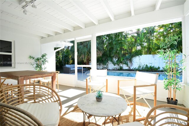 sunroom with plenty of natural light and beamed ceiling