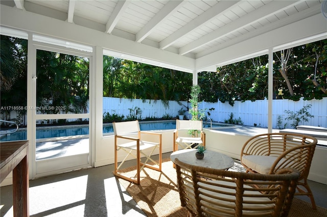 sunroom featuring beam ceiling