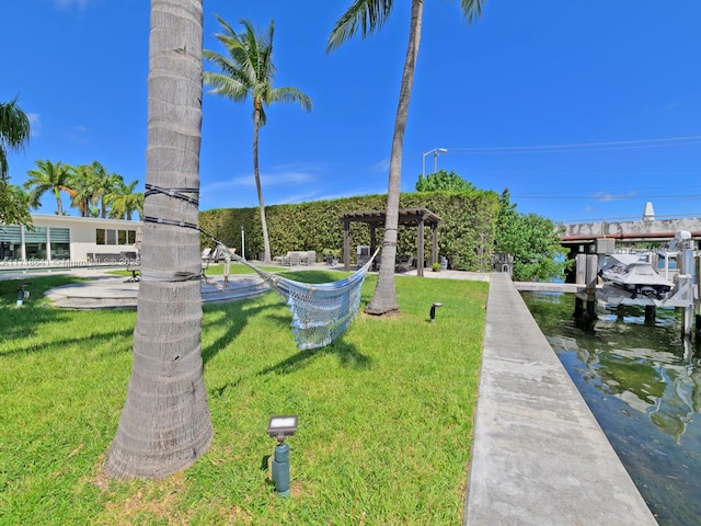 surrounding community with a lawn, a water view, and a dock