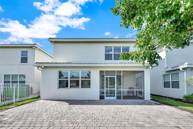 rear view of property with a patio area and a sunroom