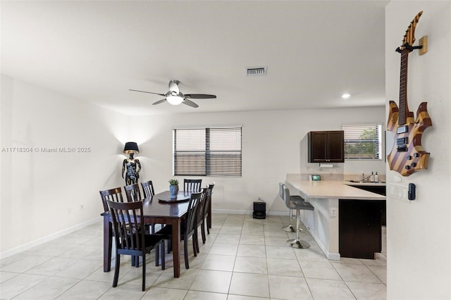 dining space featuring light tile patterned floors, ceiling fan, and sink