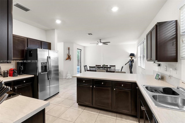 kitchen with ceiling fan, sink, kitchen peninsula, stainless steel fridge, and light tile patterned floors