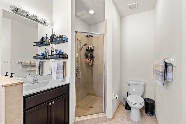 bathroom featuring tile patterned flooring, vanity, toilet, and walk in shower