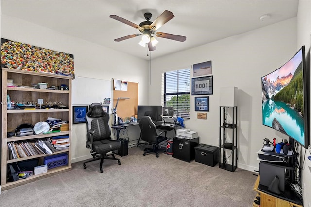 carpeted office space featuring ceiling fan