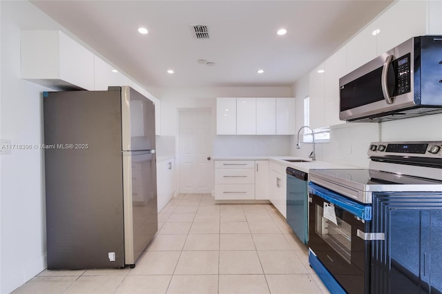 kitchen with light tile patterned flooring, white cabinetry, sink, and appliances with stainless steel finishes