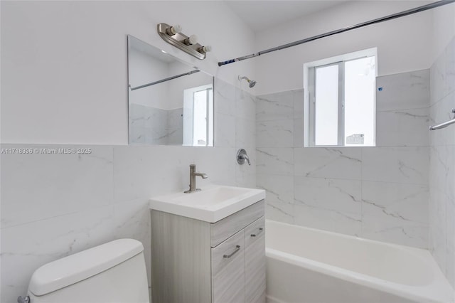 full bathroom featuring vanity, tiled shower / bath combo, tile walls, and toilet