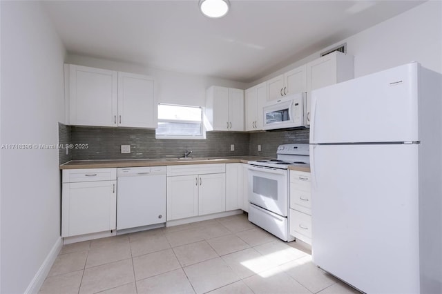 kitchen featuring white appliances, backsplash, white cabinets, sink, and light tile patterned floors