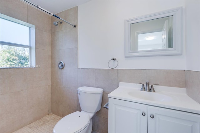 bathroom with vanity, toilet, and tiled shower