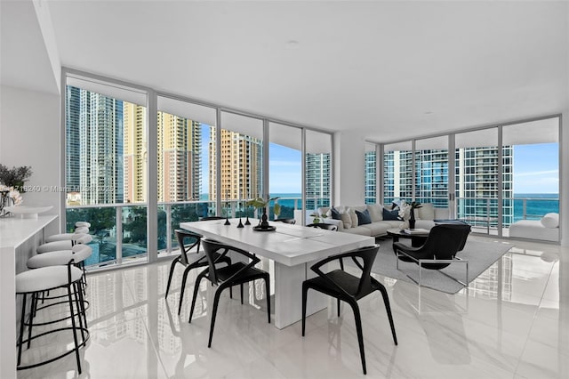 dining area with a water view and a wall of windows