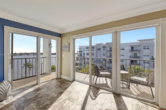 doorway to outside with a water view and ornamental molding