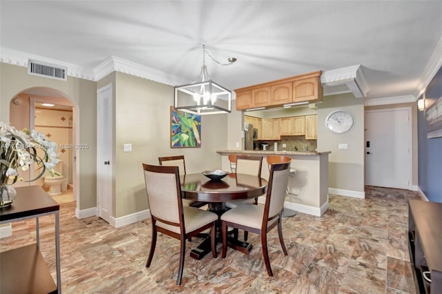 dining space featuring ornamental molding and an inviting chandelier