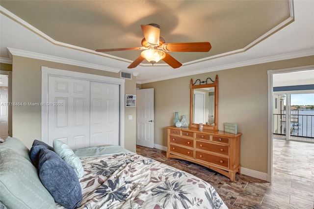 bedroom featuring ceiling fan, a raised ceiling, crown molding, access to outside, and a closet