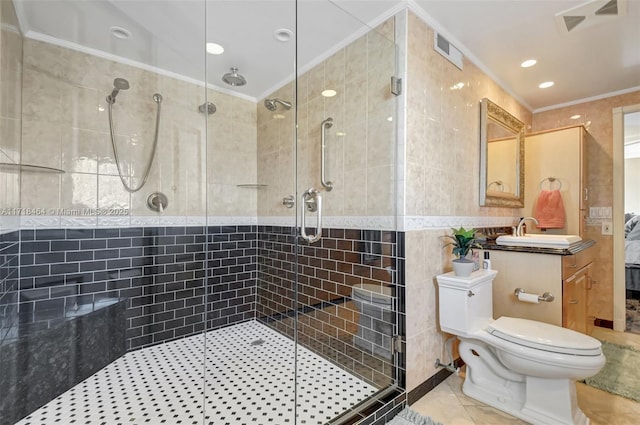 bathroom featuring tile patterned flooring, crown molding, vanity, a shower with shower door, and tile walls