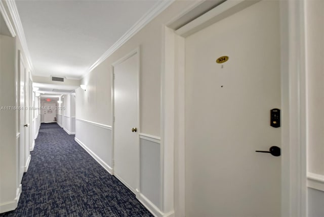 hall with dark carpet and ornamental molding