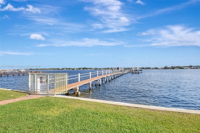 view of dock featuring a lawn and a water view