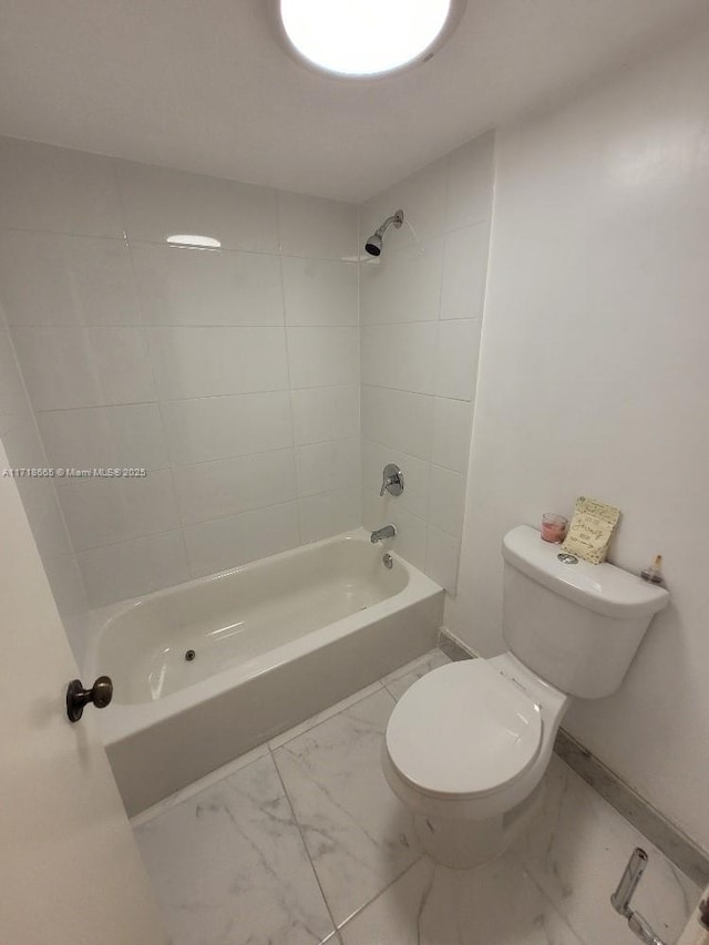 bathroom with toilet and tiled shower / bath