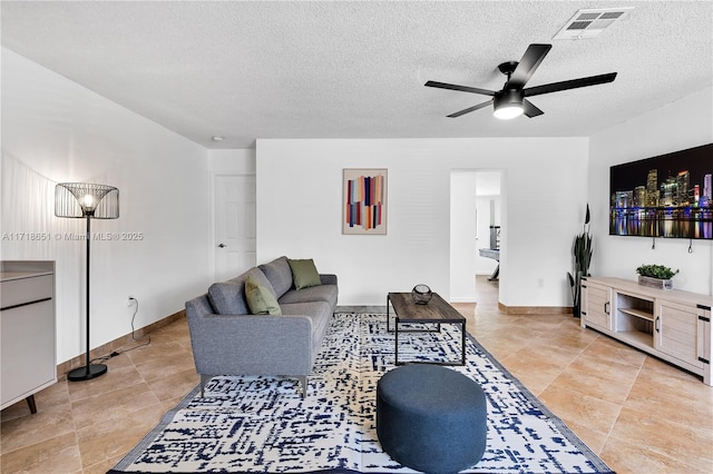 living room with a textured ceiling and ceiling fan