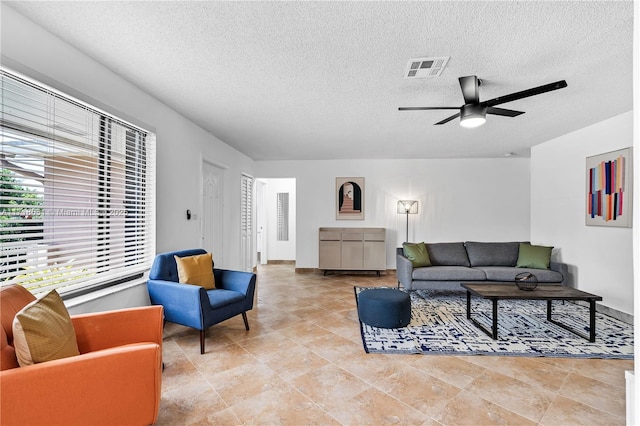 living room featuring a textured ceiling and ceiling fan