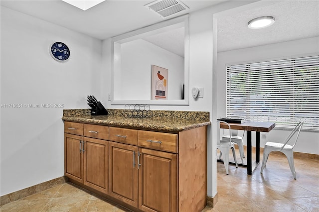 kitchen with dark stone countertops and a textured ceiling