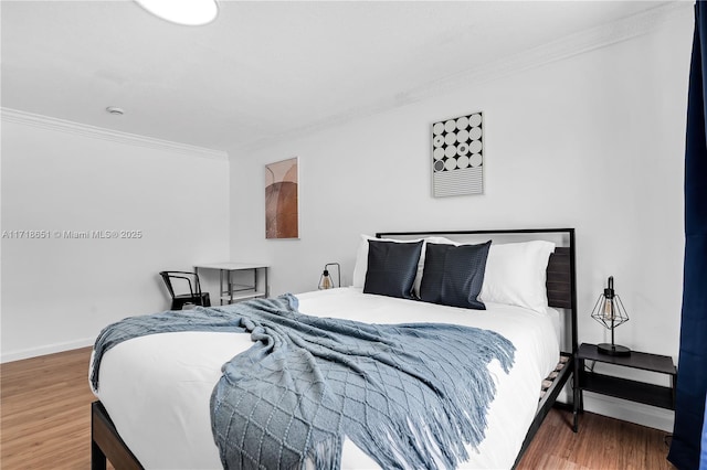 bedroom with crown molding and hardwood / wood-style floors