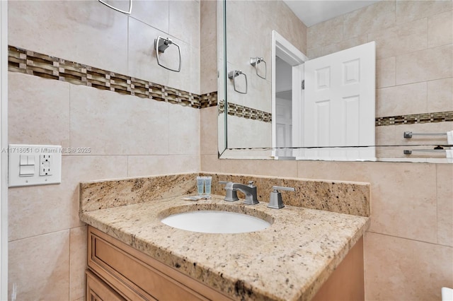 bathroom featuring vanity and tile walls