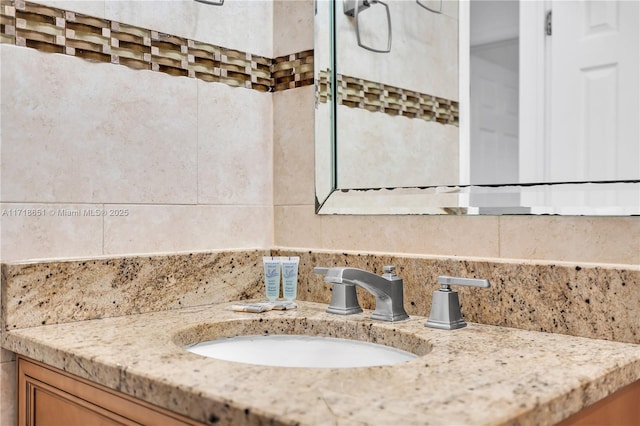 bathroom featuring vanity and backsplash