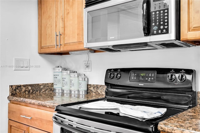 kitchen featuring black range with electric cooktop and dark stone countertops