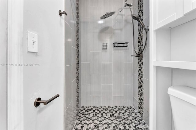 bathroom with toilet and a tile shower