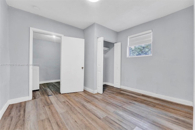 unfurnished bedroom with a closet and light hardwood / wood-style flooring