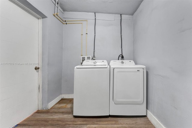 laundry area with hardwood / wood-style flooring and washer and clothes dryer