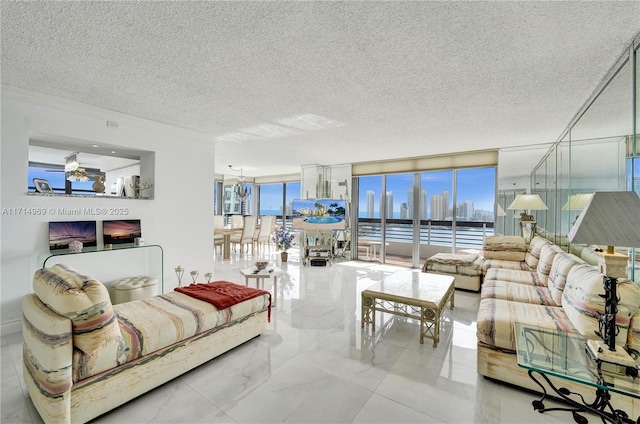 living room with plenty of natural light, a textured ceiling, and an inviting chandelier