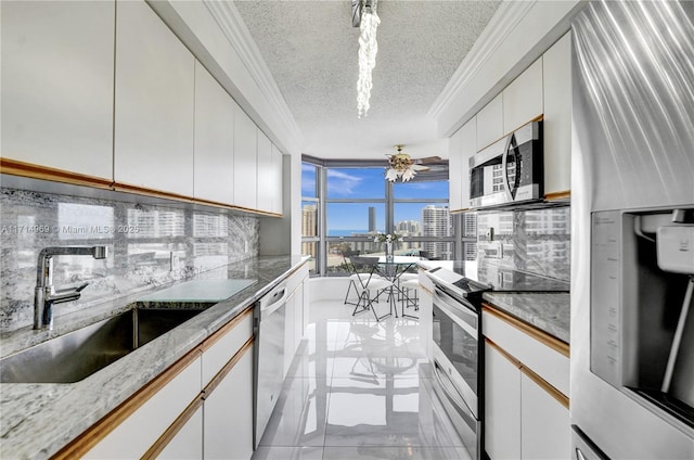 kitchen featuring a textured ceiling, stainless steel appliances, ceiling fan, sink, and white cabinets