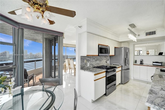 kitchen with white cabinets, decorative backsplash, ornamental molding, a textured ceiling, and appliances with stainless steel finishes