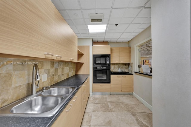 kitchen with a paneled ceiling, black appliances, sink, light brown cabinetry, and tasteful backsplash