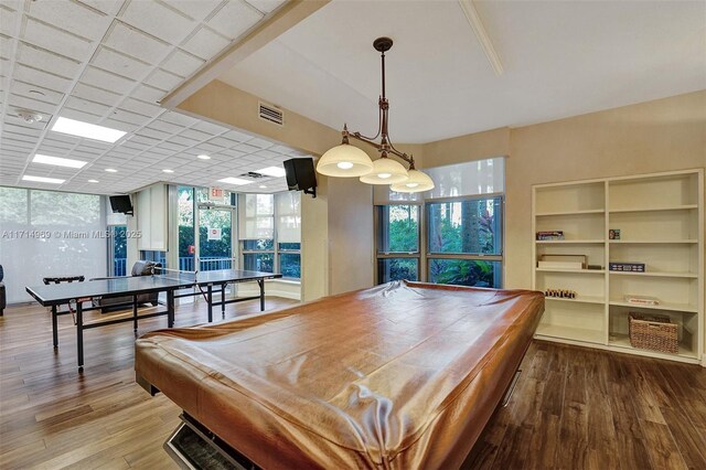 game room with a wealth of natural light, hardwood / wood-style flooring, and pool table