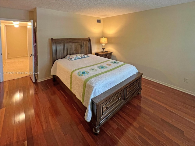 bedroom featuring dark wood-type flooring and a textured ceiling