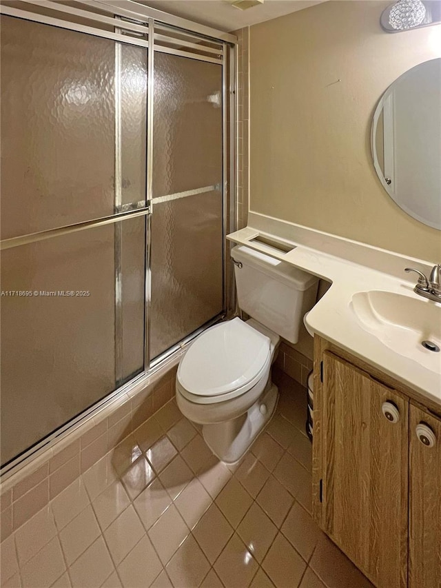 bathroom with toilet, vanity, tile patterned floors, and walk in shower