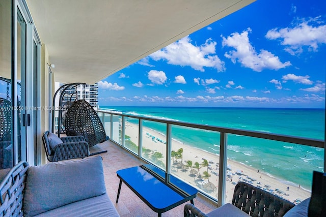 balcony featuring a beach view and a water view