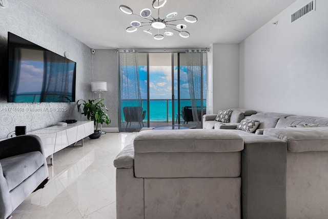 living room featuring a textured ceiling, expansive windows, and a notable chandelier